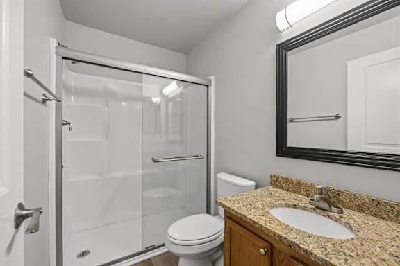 A bathroom with a toilet, sink, and shower.