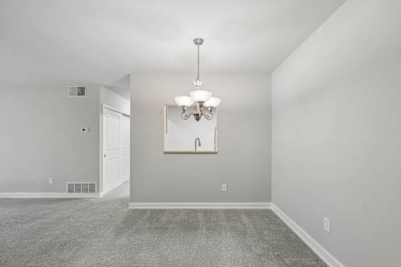 A room with a chandelier and a white door.