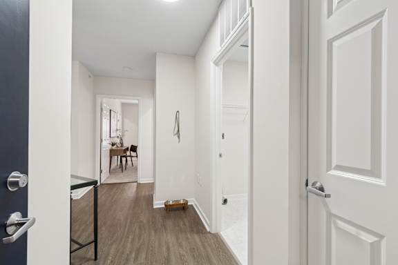 A hallway with a table and chairs in the background. at Roebling Row, Covington