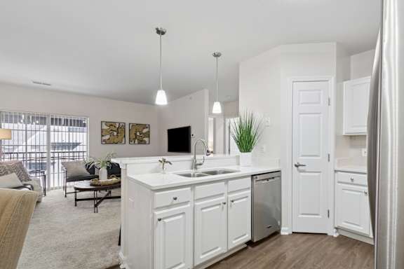 A modern kitchen with white cabinets and a large island. at Roebling Row, Covington, Kentucky