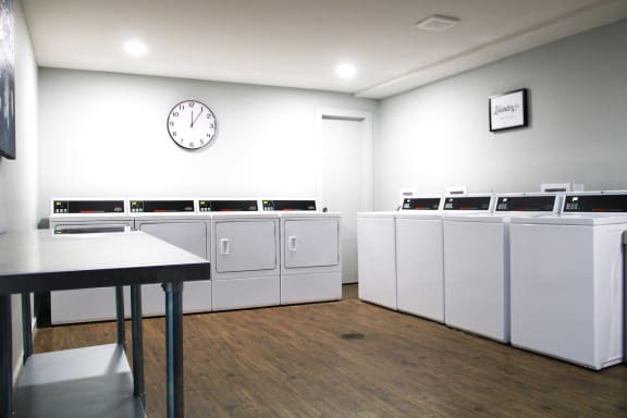 an empty laundry room with white walls and a clock on the wall at Cincinnati Premier Living*, Ohio, 45213