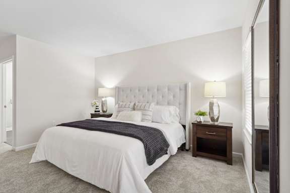 A bedroom with a large bed and two lamps. at Roebling Row, Covington, 41011-1720