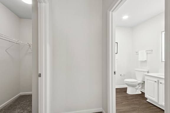 A white bathroom with a toilet, sink, and a white cabinet. at Roebling Row, Kentucky