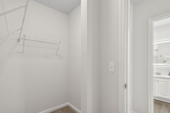A white closet with a shelf and a mirror in the adjacent room. at Roebling Row, Covington, Kentucky