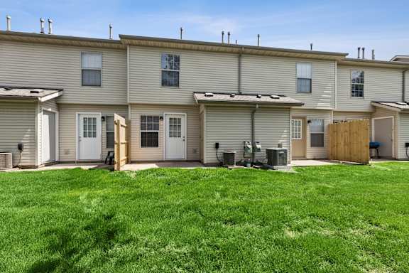 A row of houses with green lawns in front.