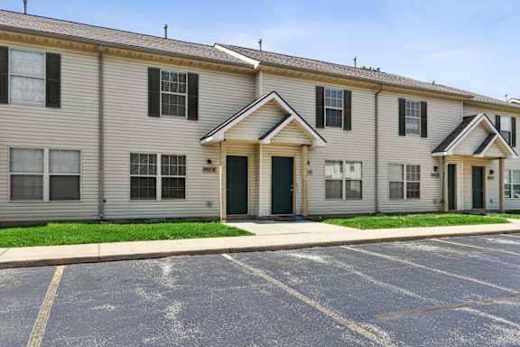 A row of townhouses with a parking lot in front.