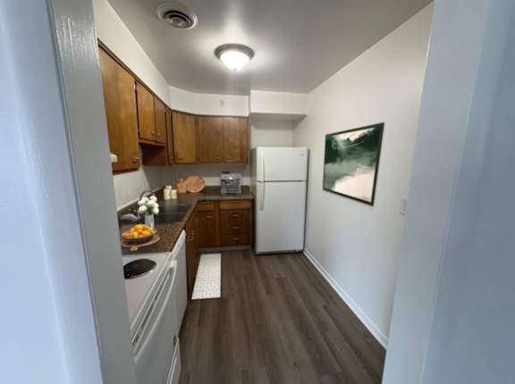 A kitchen with wooden cabinets and a white refrigerator.