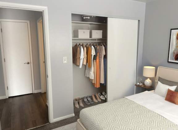A bedroom with a bed, a wardrobe, and a painting on the wall.