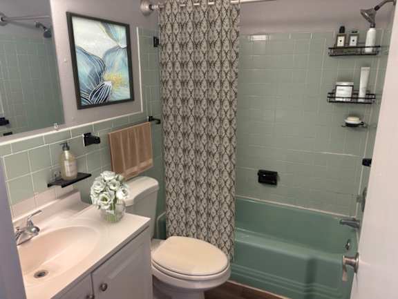 A bathroom with a toilet, sink, and shower.
