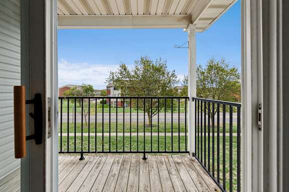 A view from a doorway looking out to a deck with a black railing.