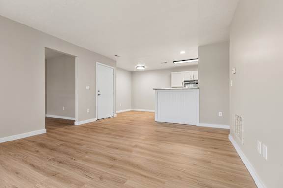 A room with wooden flooring and white walls.