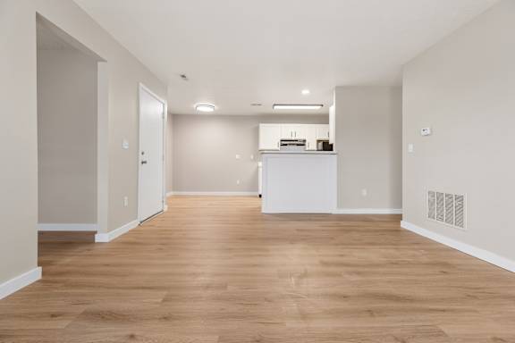 A room with wooden flooring and white walls.