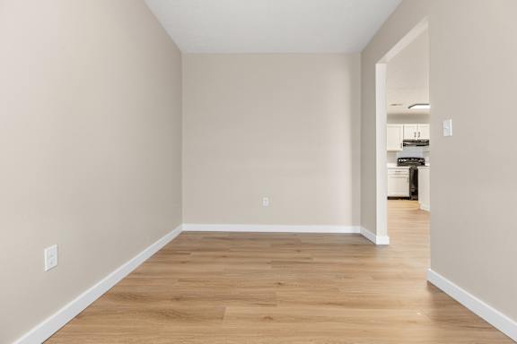 A room with wooden flooring and white walls.