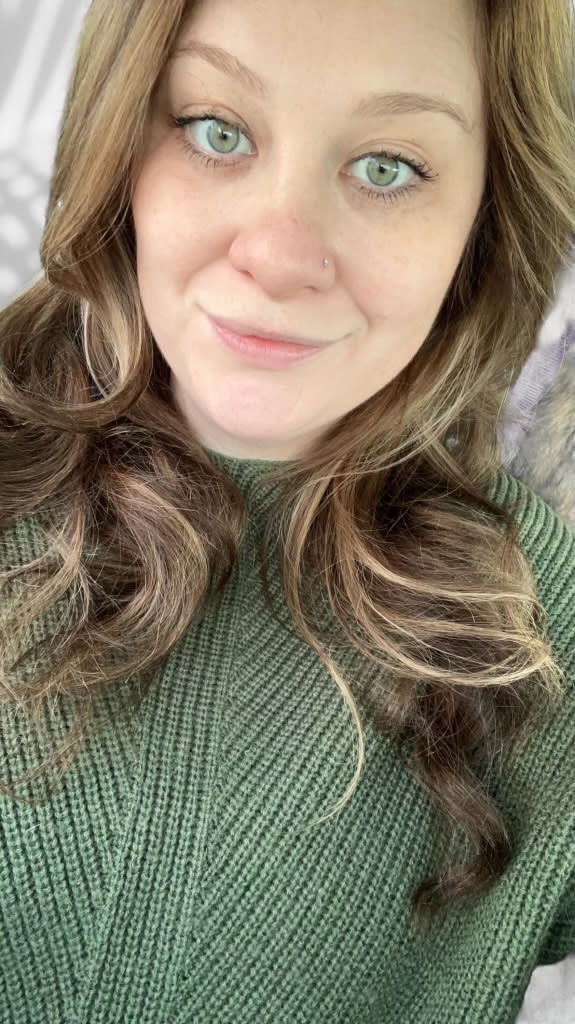 a woman with long hair and green eyes and a green sweater