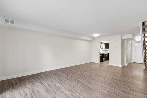 A room with wooden flooring and white walls.