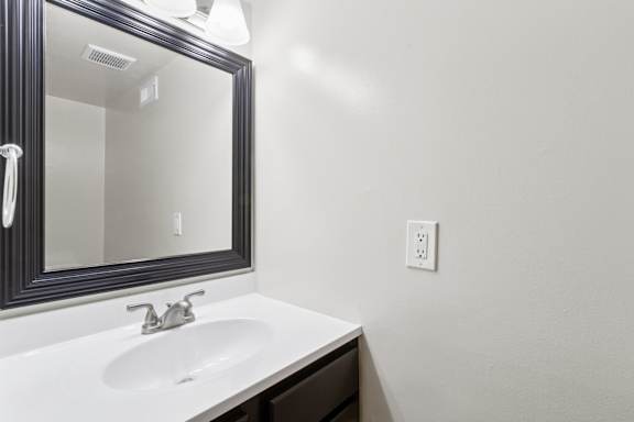 A white sink under a mirror in a bathroom.