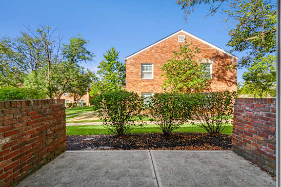 A red brick house with a small garden in front.