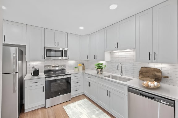 a white kitchen with stainless steel appliances and white cabinets at Indian Creek Apartments*, Cincinnati, OH, 45236
