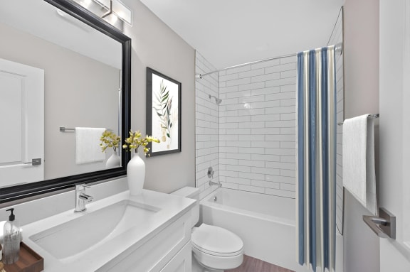a white bathroom with a large mirror and a tub and a sink at Indian Creek Apartments*, Cincinnati