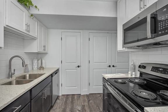 a kitchen with white cabinets and black appliances and a sink at Ivy Hills Living Spaces, Ohio, 45244
