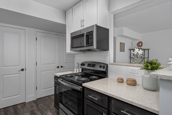 a kitchen with white cabinets and a black stove at Ivy Hills Living Spaces, Cincinnati, 45244