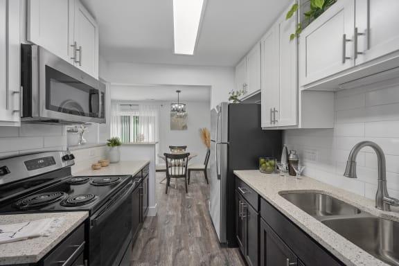 a kitchen with black appliances and white cabinets at Ivy Hills Living Spaces, Ohio