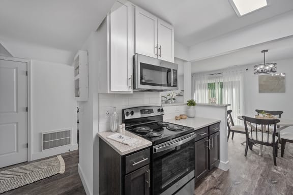 a kitchen with white cabinets and a stove and a microwave at Ivy Hills Living Spaces, Cincinnati, Ohio