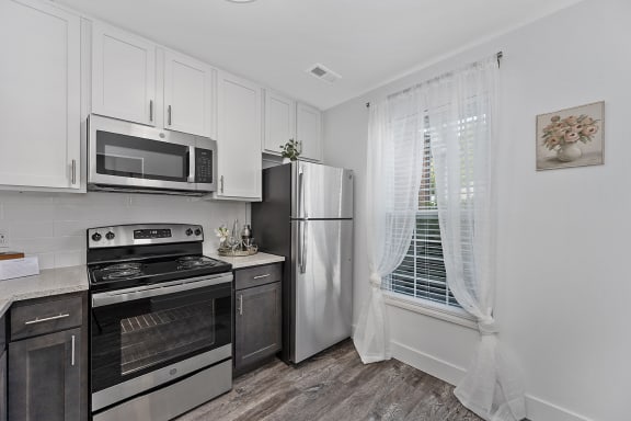 a kitchen with stainless steel appliances and white cabinets at Ivy Hills Living Spaces, Ohio