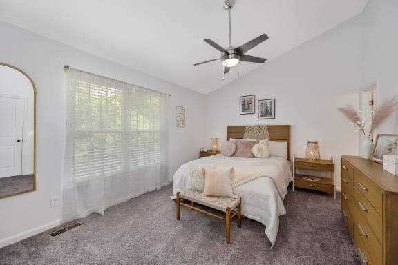 an empty bedroom with a bed and a ceiling fan at Ivy Hills Living Spaces, Ohio