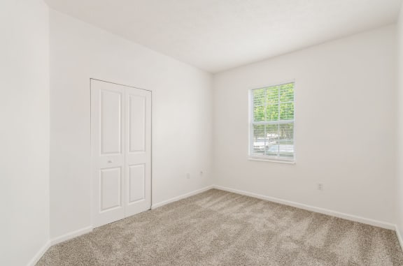 a bedroom with carpet and a window
