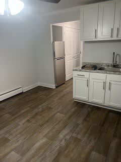 A kitchen with a refrigerator and cabinets.