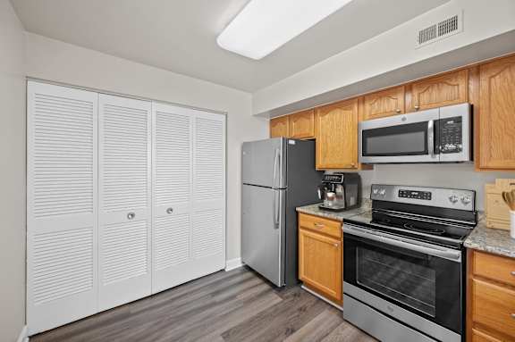 A kitchen with wooden cabinets and stainless steel appliances. at Indian Creek Apartments*, Cincinnati, OH
