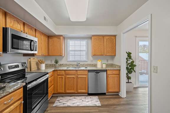 A kitchen with wooden cabinets and a black stove top oven. at Indian Creek Apartments*, Cincinnati, OH, 45236