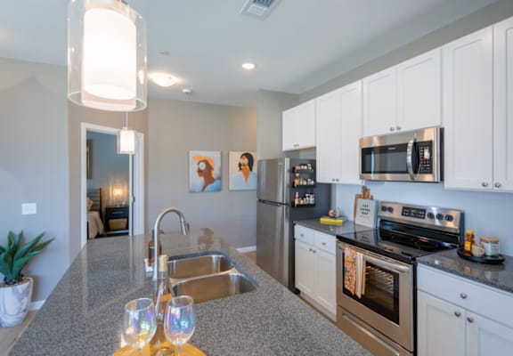A modern kitchen with stainless steel appliances and white cabinets.