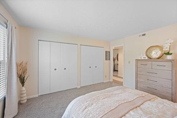 A bedroom with a bed, dresser, and wardrobe.