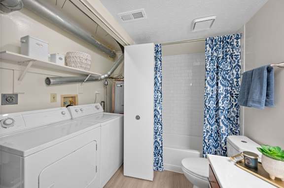 A white washing machine and dryer in a small laundry room.