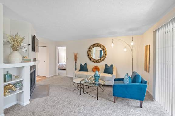 A living room with a blue couch and a fireplace.