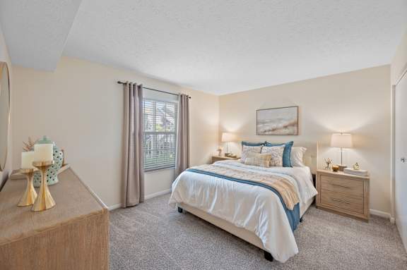 A bedroom with a bed, nightstand, and dresser.