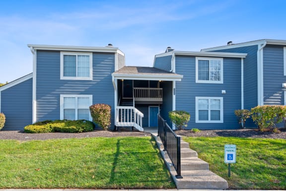 a blue house with a lawn and stairs in front of it