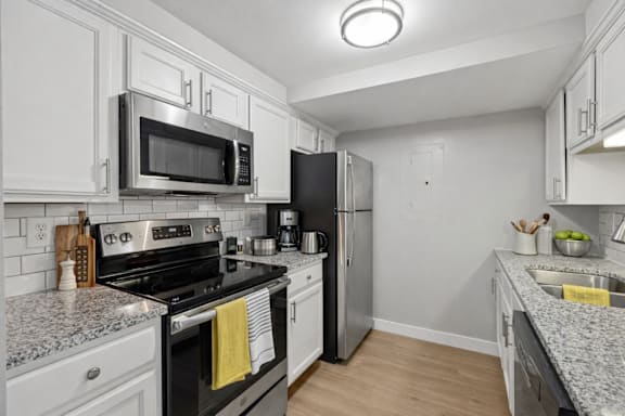 A kitchen with a black stove top oven and a black refrigerator.