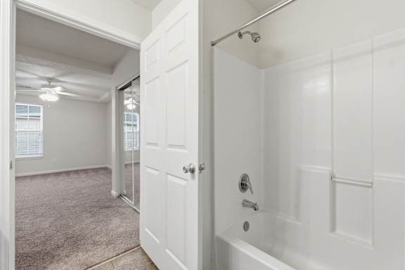 A white bathroom with a tub and a shower.