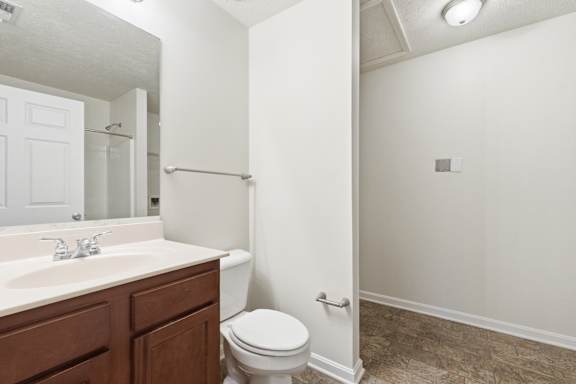 A white bathroom with a toilet, sink, and shower.