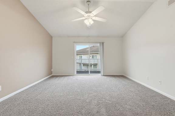 A spacious room with a ceiling fan and carpeted floor.