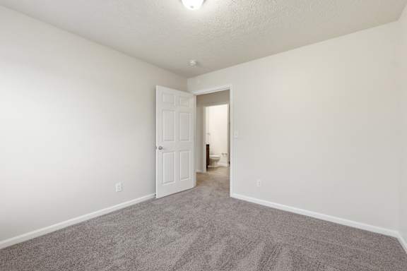 A room with a carpeted floor and a white door.