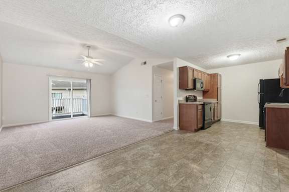 A spacious living room with a kitchenette and a balcony.