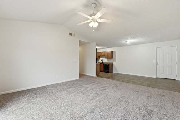 A room with a ceiling fan and a carpeted floor.