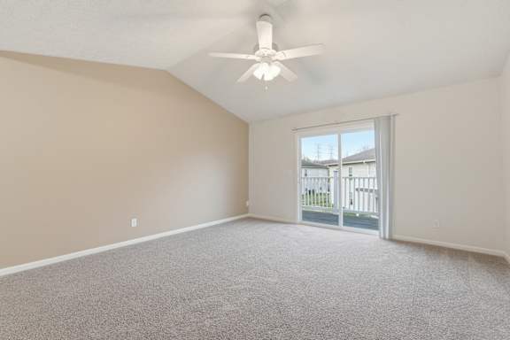 A room with a ceiling fan and a sliding glass door leading to a balcony.