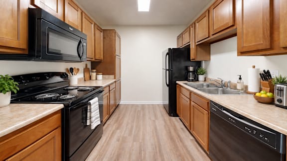 A kitchen with black appliances and wooden cabinets.