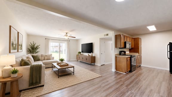 A living room with a couch, a coffee table, a television, and a refrigerator.