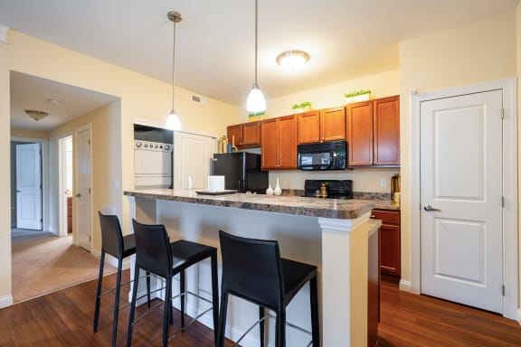a kitchen with a large counter top with three stools  at Grove City Summit, Grove City, Ohio